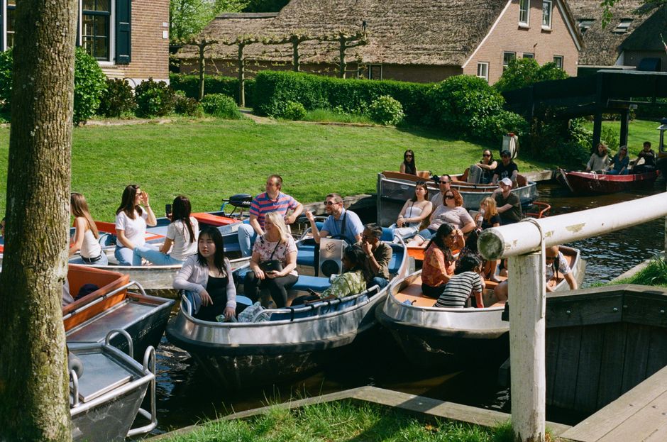 A group enjoys leisure boating in a sunny rural setting with lush greenery.